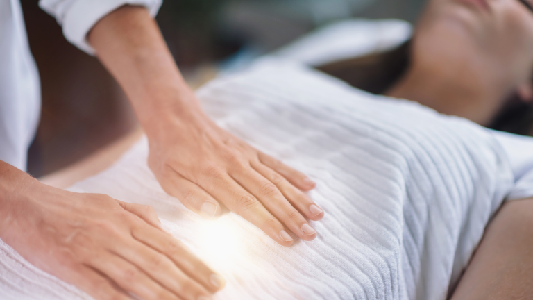 Hands hovering over a person during an intuitive energy healing session.